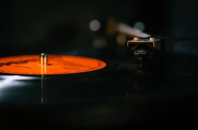 Detailed still life of a turntable needle on a spinning vinyl record, capturing the analog music experience.
