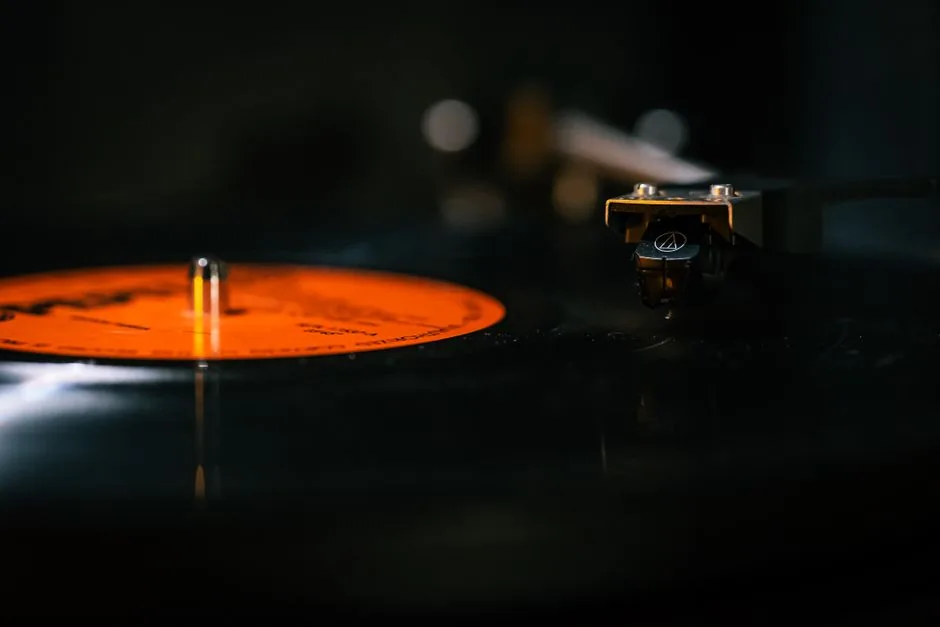 Detailed still life of a turntable needle on a spinning vinyl record, capturing the analog music experience.